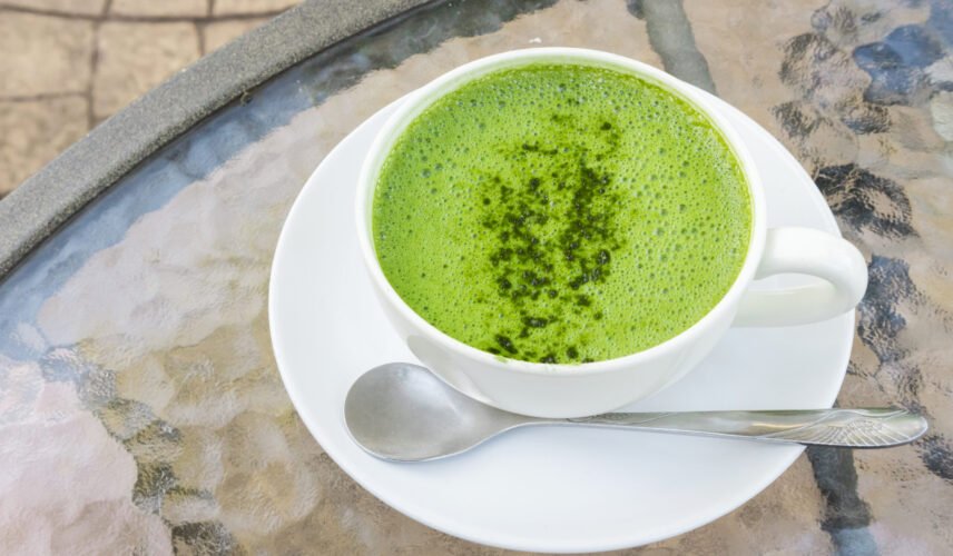 Closeup a cup of matcha latte or green tea on glass table backgr Closeup a cup of matcha latte or green tea on glass table background